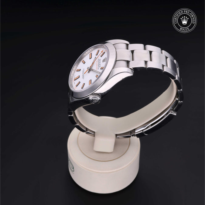 Silver watch on a white stand with a dark background