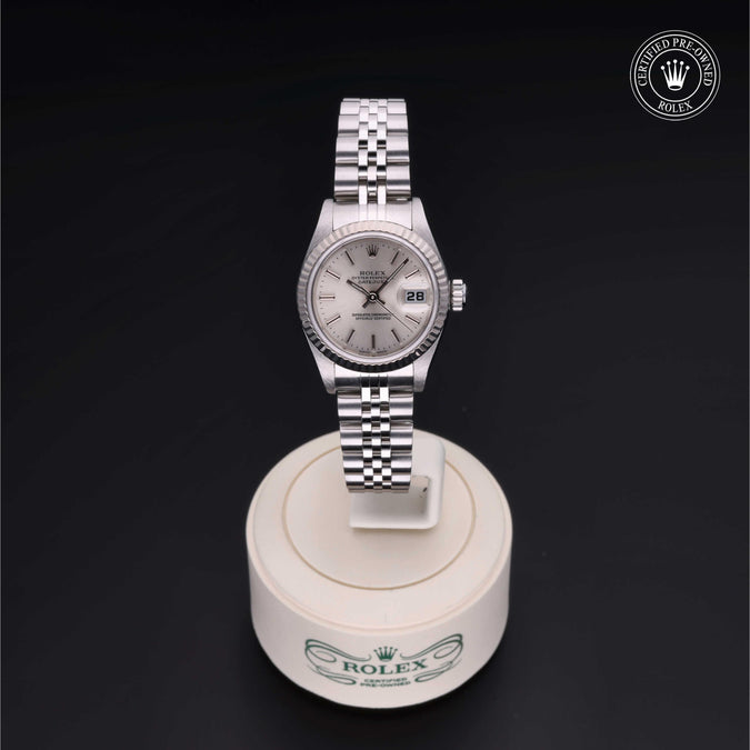 Silver Rolex watch on a white stand with a black background