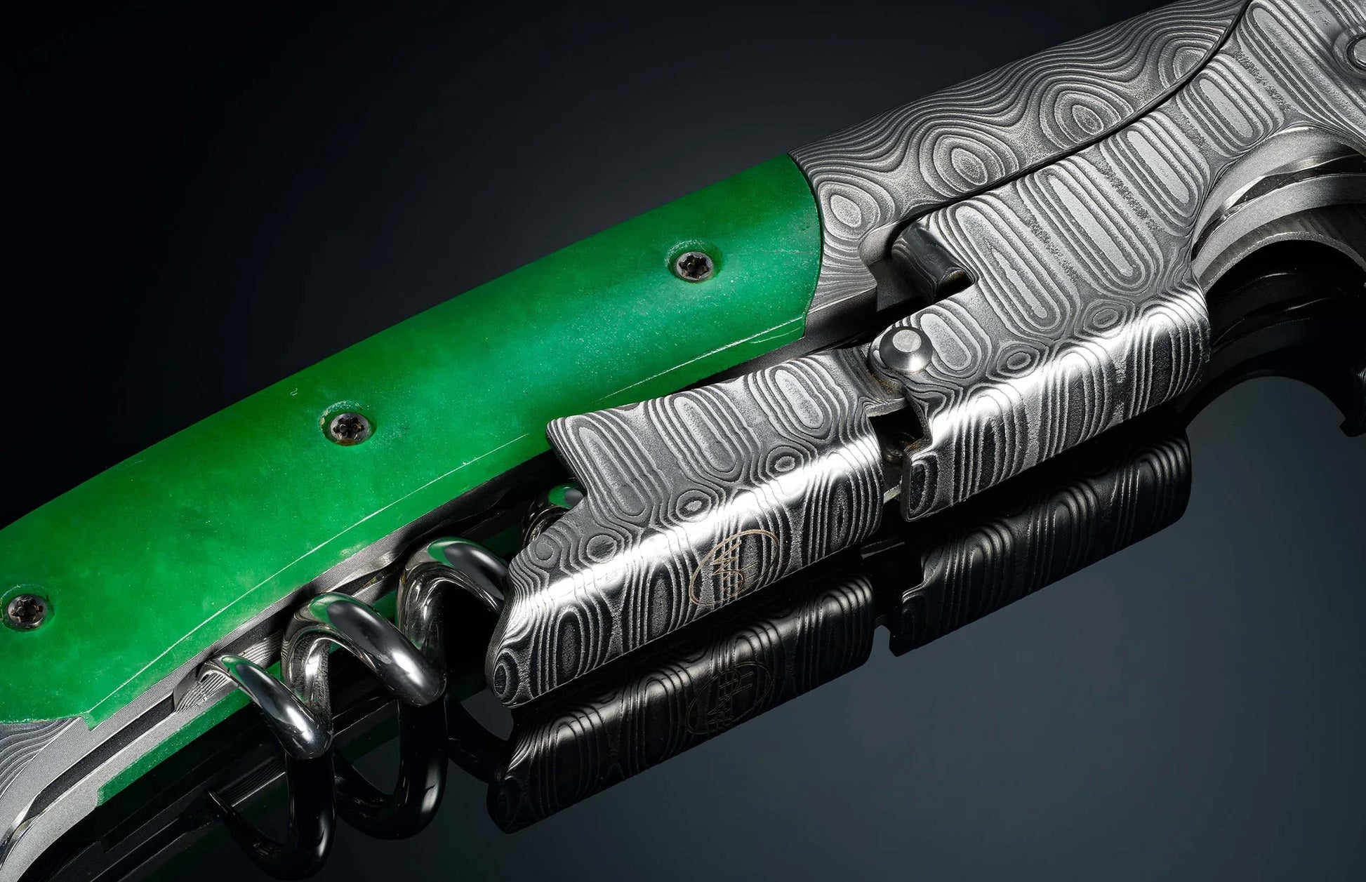 Close-up of William Henry Canopy corkscrew with Damascus steel pattern and green handle on black reflective surface