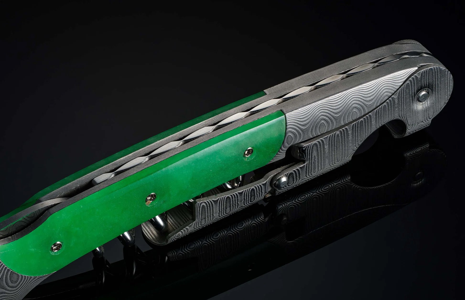 Angled view of William Henry Canopy wine opener showcasing green jade handle and damascus steel frame on black background