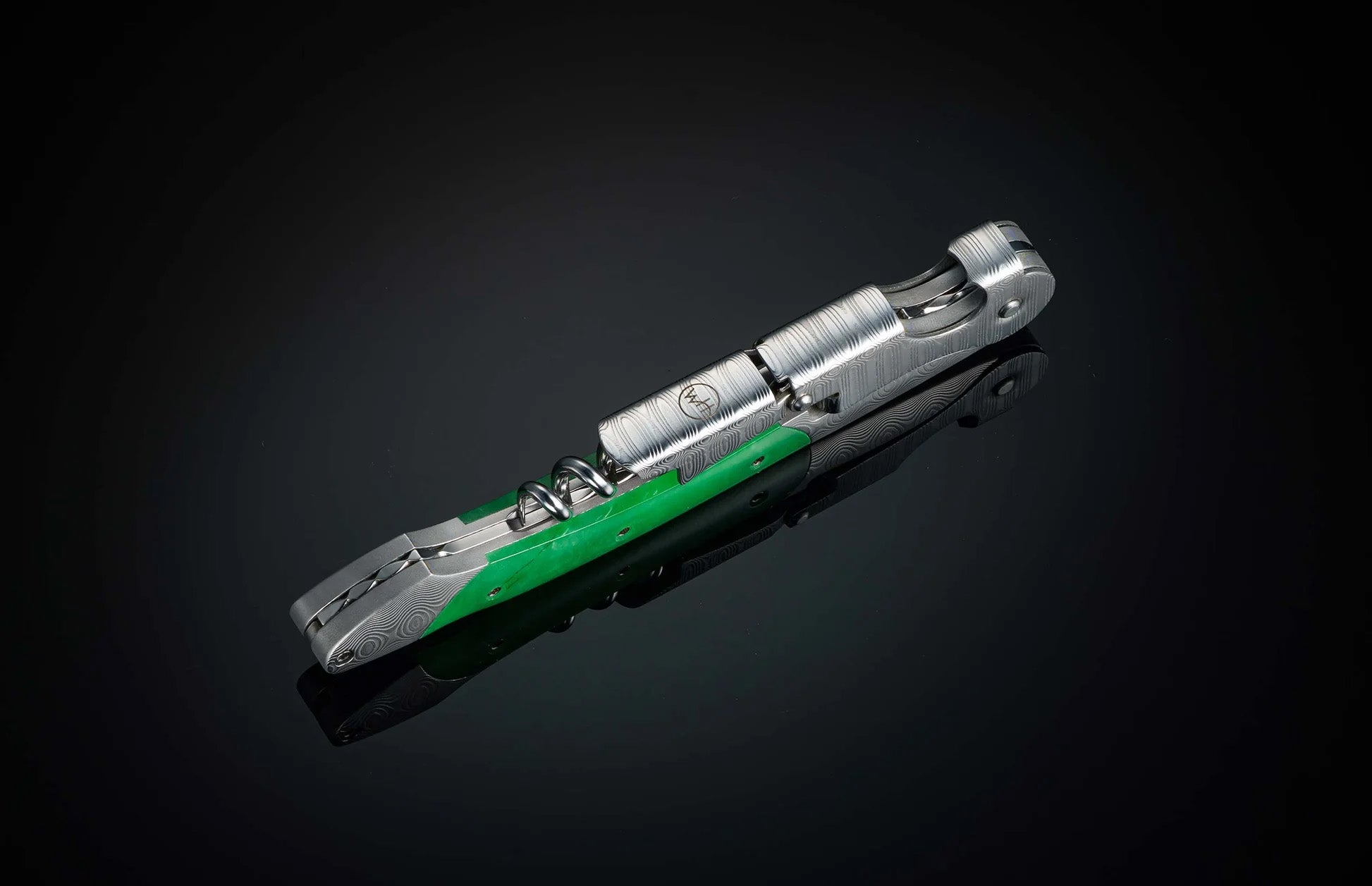 Angled view of William Henry Canopy wine opener showcasing steel body, green inlay and exposed corkscrew on dark background