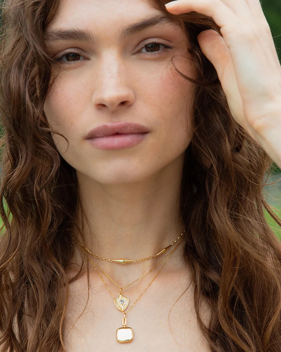 upclose of a woman wearing gold necklaces