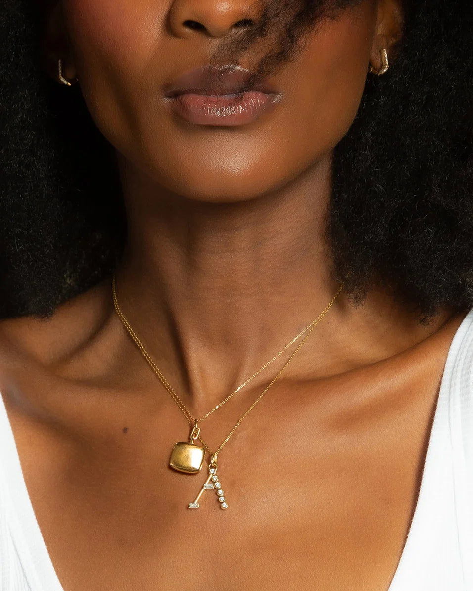 upclose of a women wearing a white shirt and gold necklaces