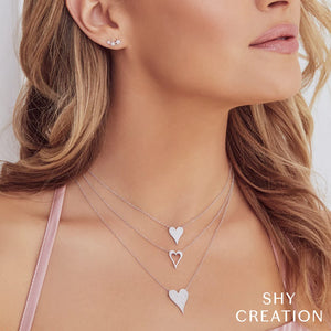 Model wearing three-layer silver heart necklaces and small star stud earrings; text 'SHY CREATION'.