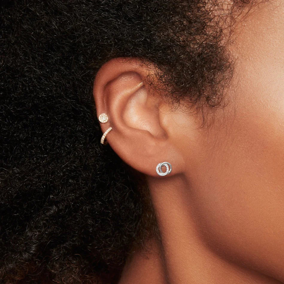 Close-up of Diamond Love Knot Circle earring in 14K white gold showcasing interlocking circles with diamond pave on model ear