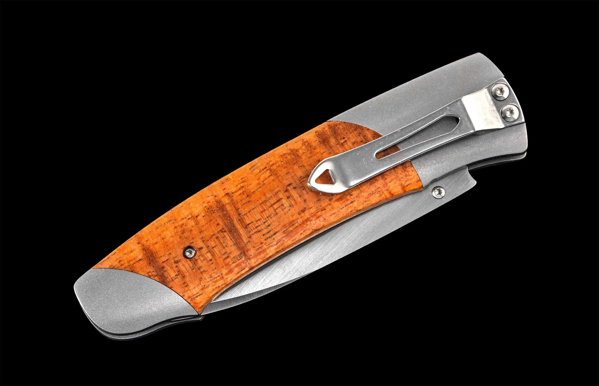 Foldable knife with wooden handle on a black background