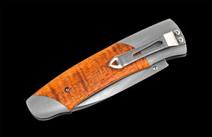 Foldable knife with wooden handle on a black background