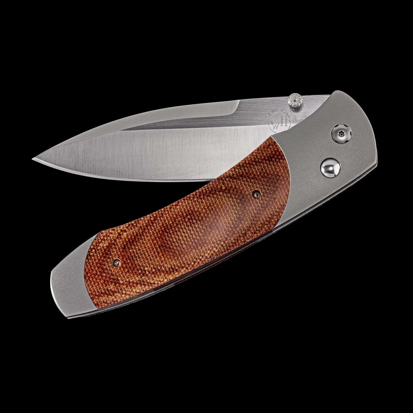 A folding pocket knife with a satin-finished steel blade and a textured brown wood handle scale, shown open against a solid black background.