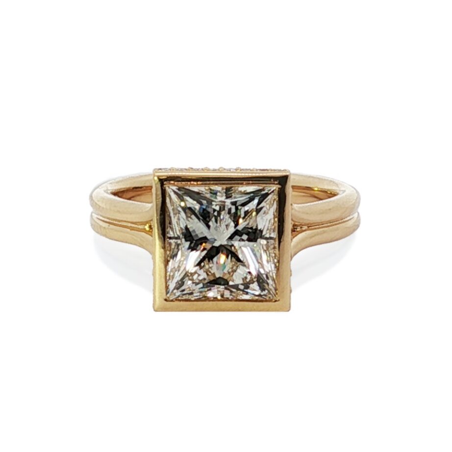 Front view of princess-cut diamond engagement ring in 18K yellow gold bezel setting on white background