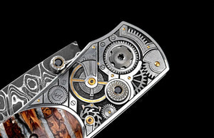 Close-up of B12 Watch Gears knife showing engraved watch-gear bolsters with 24K gold and ruby inlays and mammoth tooth handle