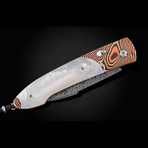 A folding pocket knife with a patterned Damascus steel blade, a white mother-of-pearl inlay, and a handle featuring orange, brown, and black wood grain swirls, shown against a dark background.