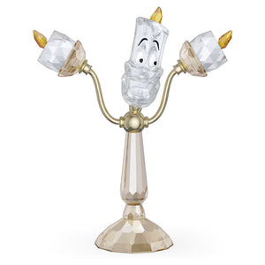 Lumière candle with gold tone finishes with clear and champagne colored crystals on a white background
