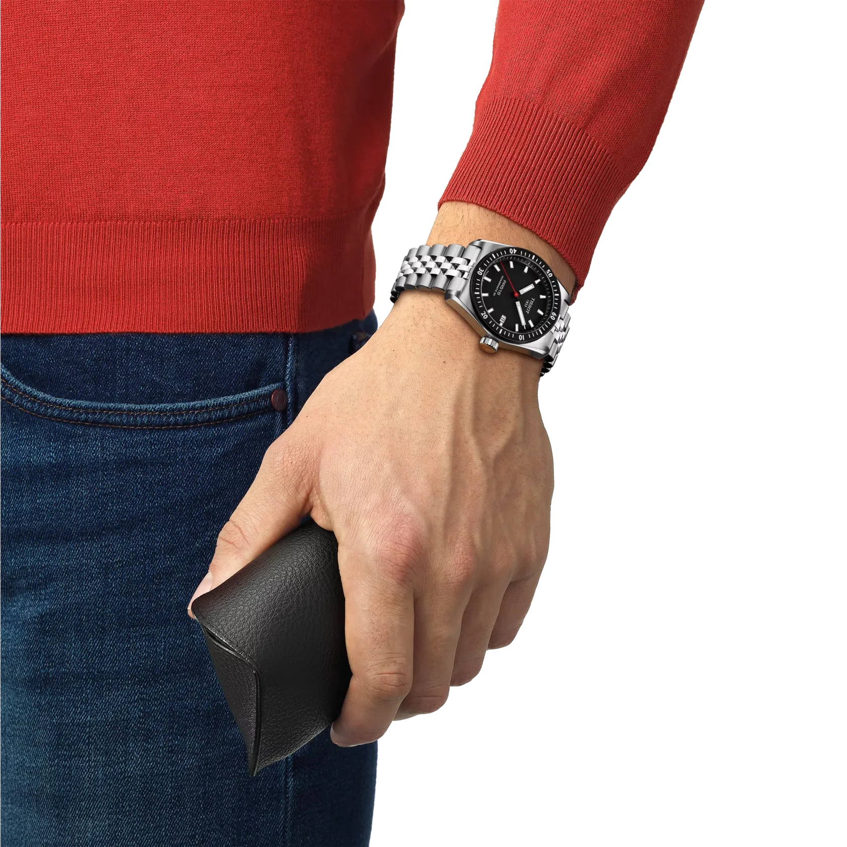 Hand wearing a silver watch holding a black wallet, with a red sweater and blue jeans.
