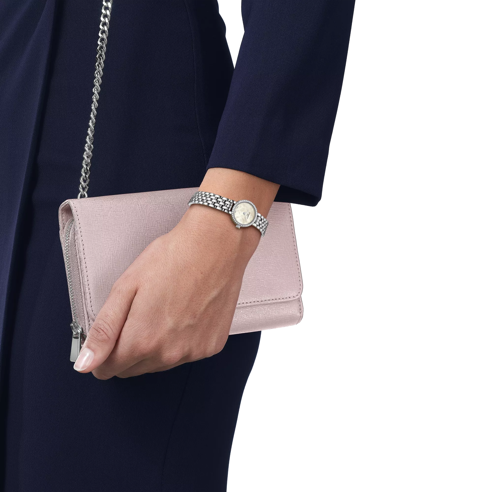 Hand holding a pink clutch bag with a silver chain, wearing a watch on a white background