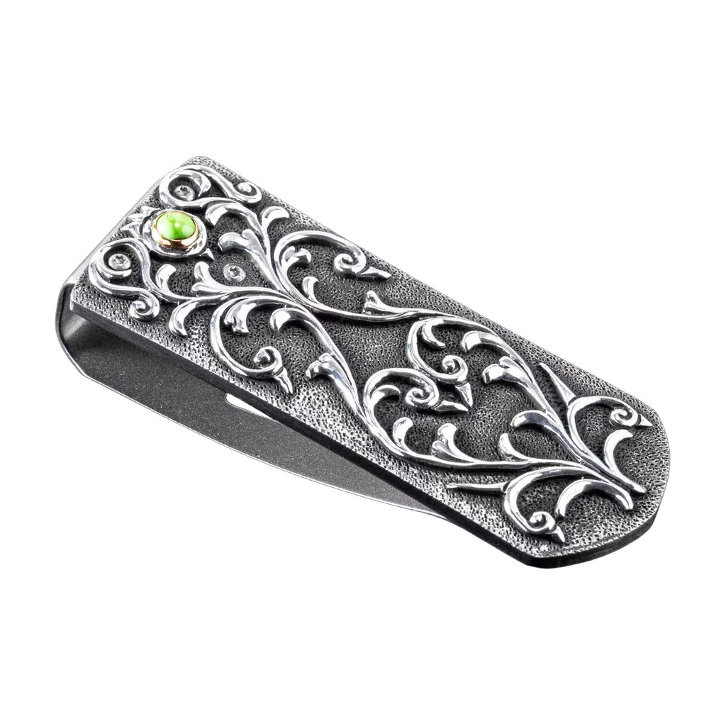 Angled view of William Henry Zurich Carico Lake money clip with carved sterling silver scrollwork and green turquoise inset