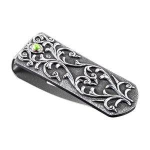 Angled view of William Henry Zurich Carico Lake money clip with carved sterling silver scrollwork and green turquoise inset