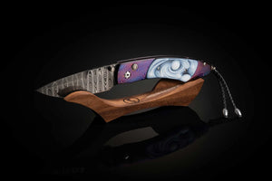 Handcrafted knife with wooden handle and decorative blade on a black background