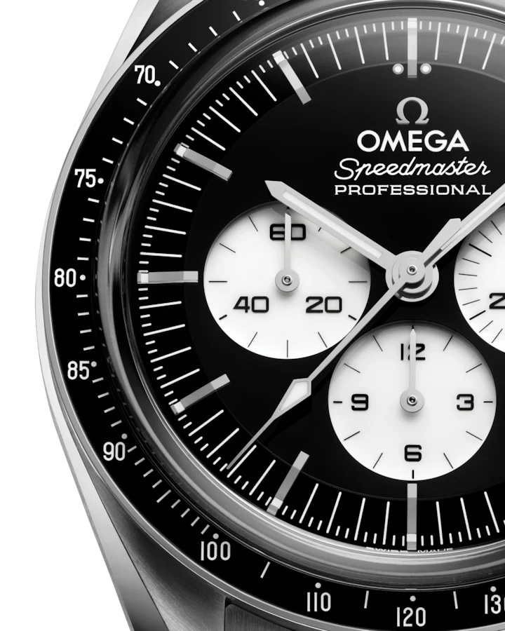 Up close view of a Omega steel watch with black dial on white background