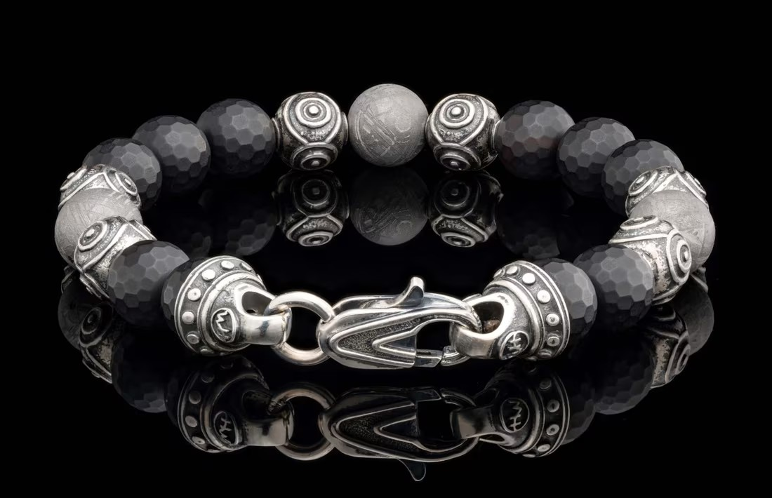 William Henry Monomyth bracelet — faceted black onyx beads and engraved silver beads with decorative clasp and reflection.