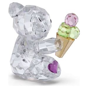 side view of multicolored bear holding an ice cream cone on a white background