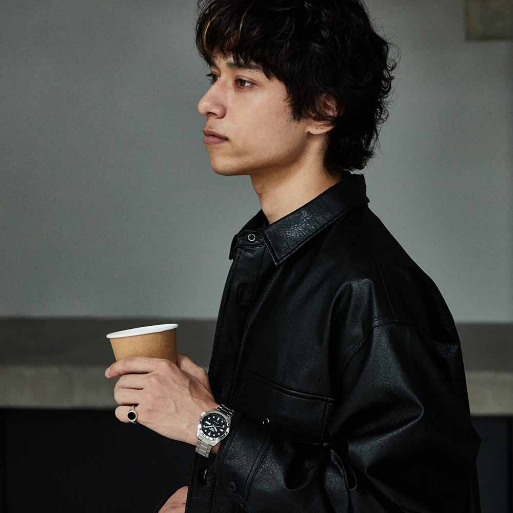 Man holding a coffee cup with a neutral background