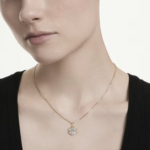 up close of a woman wearing a black shirt and a gold tone snowflake necklace