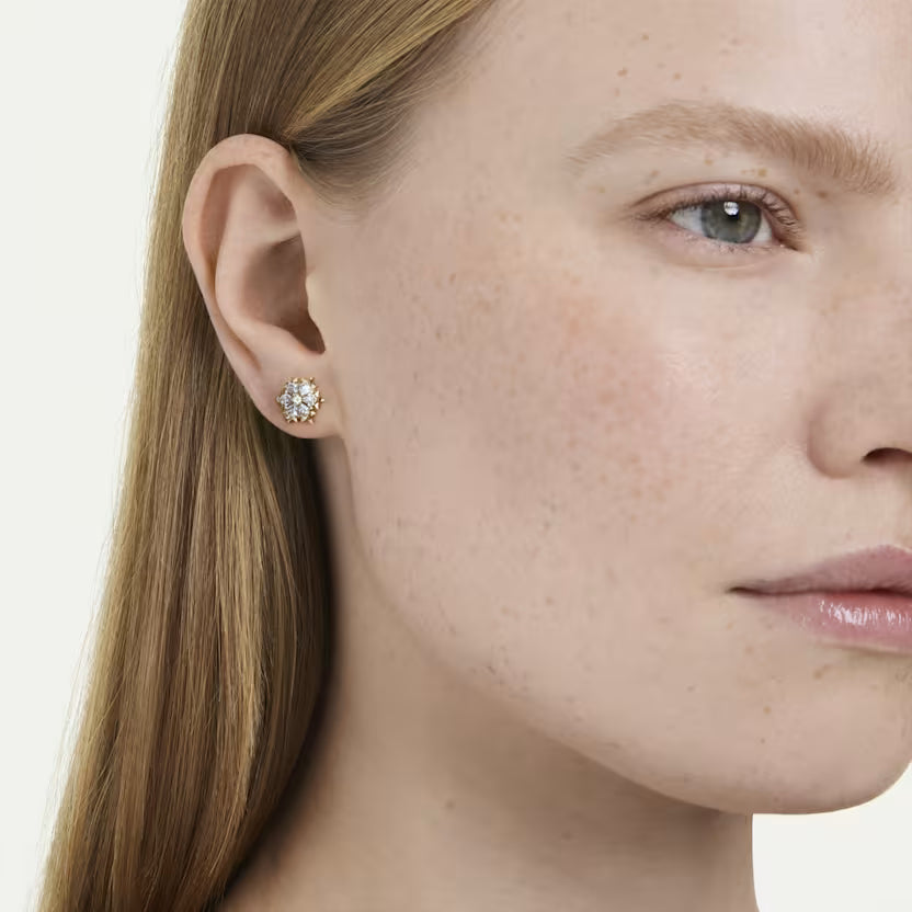 woman wearing snowflake earrings with a gold finish