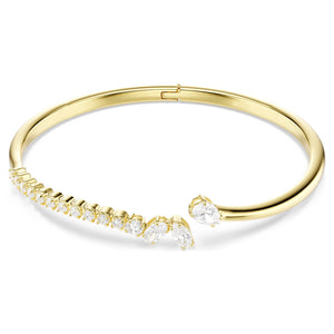 gold tone open bangle with mixed cut stones on a white background