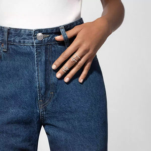 Person wearing blue jeans with a close-up of a hand adorned with 1ctw White Gold Double Pavé Diamond Ring