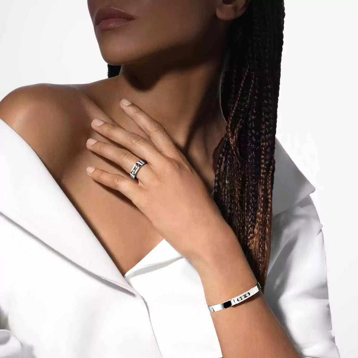 Woman wearing a silver ring and bracelet on a white background