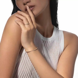 Woman wearing a gold ring and bracelet on a white background