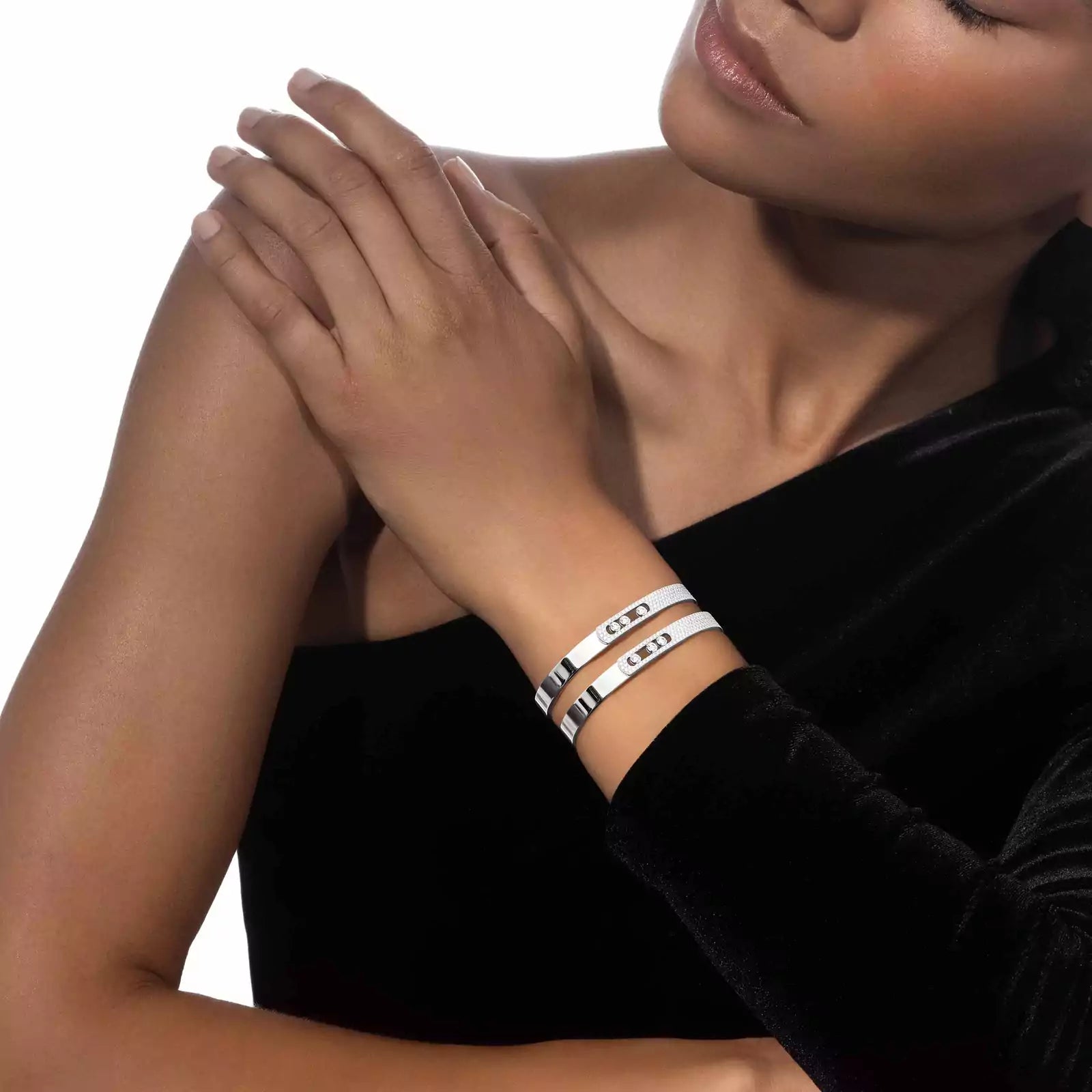woman wearing a black dress and white gold bangle bracelets