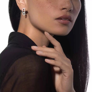Close-up of a person wearing a black garment with a white background and White Gold Diamond Earrings