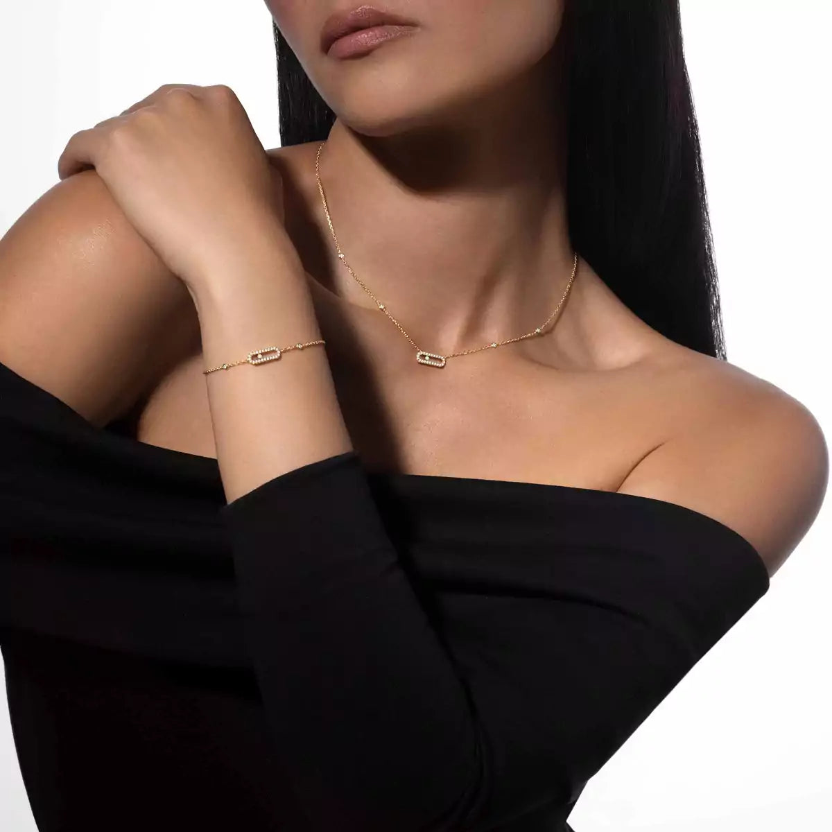 Woman wearing a gold necklace and bracelet on a white background