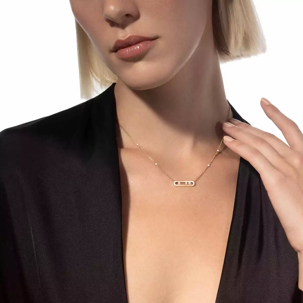 Woman wearing a gold necklace with a plain background