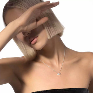 Woman wearing a necklace with an eye pendant on a white background