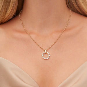 Front view of Large Cloud pendant necklace in yellow gold showcasing circular diamond cluster and square bail on a delicate chain against model's bare décolletage