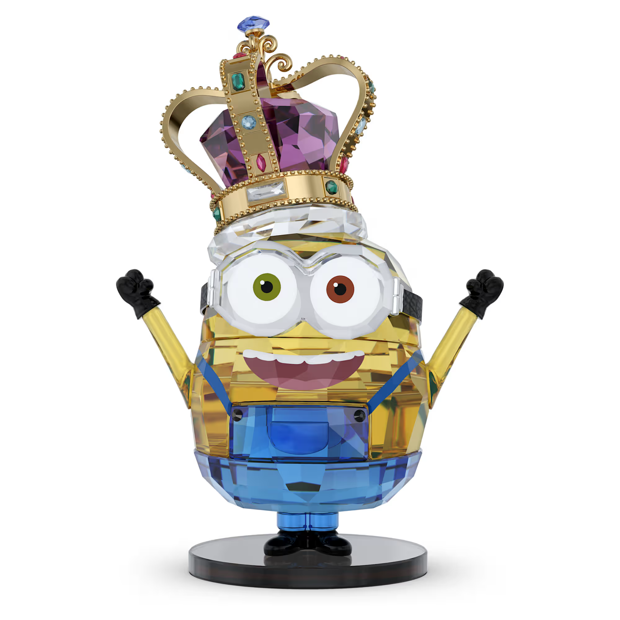 Crystal figurine of a crowned Minion with mismatched eyes, blue overalls and raised arms on a round base.
