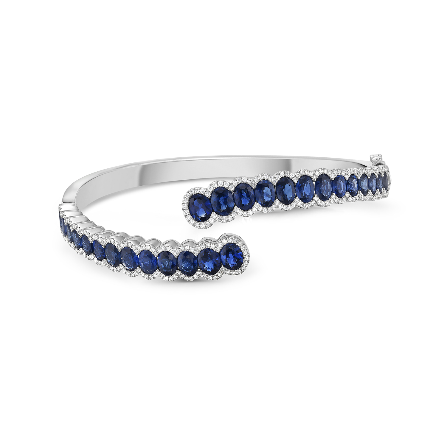 white gold bracelet cuff with blue oval sapphires with diamonds around the sapphires on white background