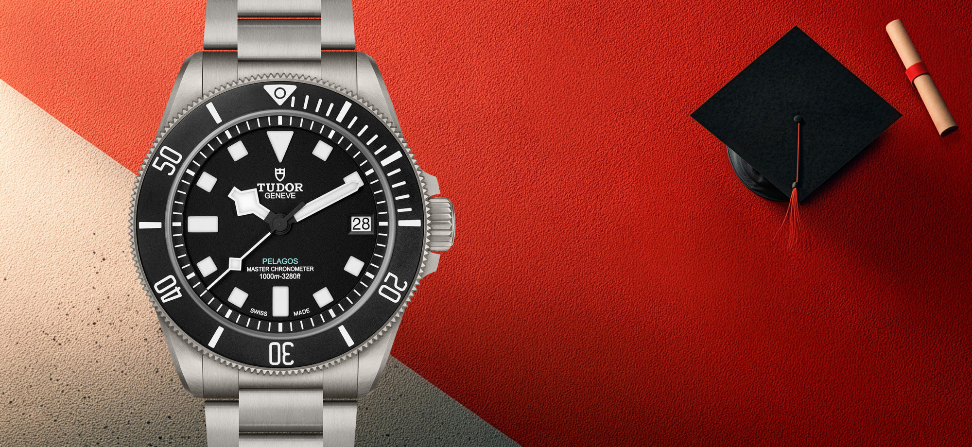 Tudor watch with black dial and steel bezel and a red and tan background with graduation cap and diploma