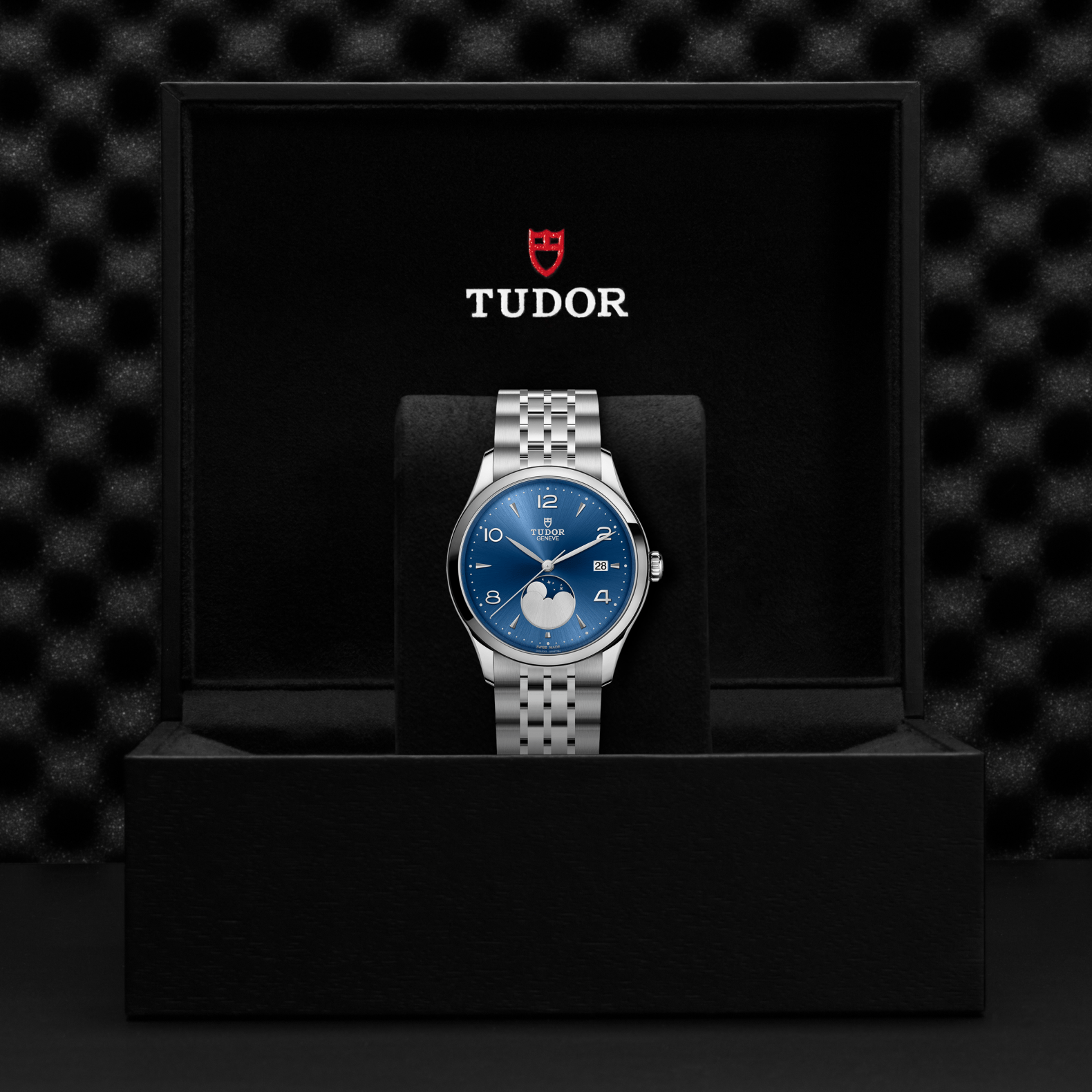 Front view of TUDOR 1926 Luna 39mm steel watch with blue sunburst dial, moonphase and date, steel bracelet in black box