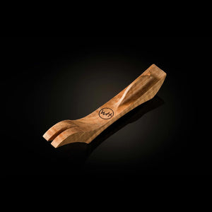 A carved wooden pocket knife holder with a polished finish and a circular 'W.H' logo engraved on the side, set against a dark reflective background.