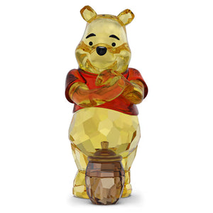 winnie the pooh crystal figurine with a pot of honey by his feet on a white background