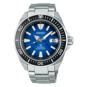 Seiko watch with blue face and silver metal strap on black background