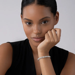 Close-up of wrist wearing 6mm Three Station X Caviar bracelet showing silver caviar beading and three sterling X stations on light gray
