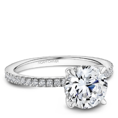 Angled view of 0.27ctw engagement ring with round center diamond in four-prong and pavé platinum band, engraved Noam Carver