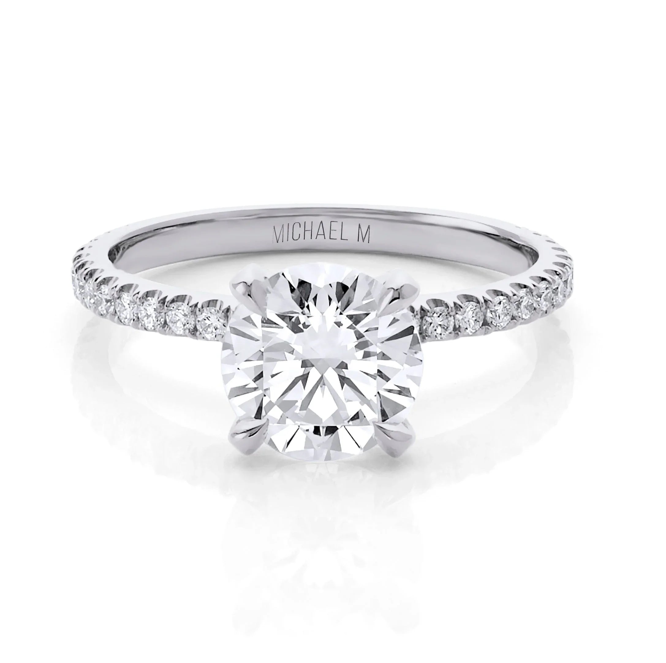 Round brilliant solitaire engagement ring with pavé diamond band, engraved "MICHAEL M" inside the band.
