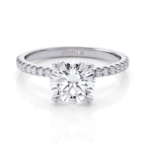Round brilliant solitaire engagement ring with pavé diamond band, engraved "MICHAEL M" inside the band.