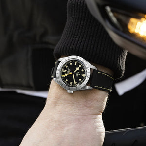 Close-up of TUDOR Black Bay Pro 39mm steel watch on wrist showcasing 24-hour bezel and black rubber-leather strap with yellow stitching